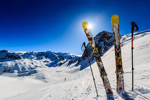 Skier glänzen in der Nachmittagssonne im Schnee in den Bergen.