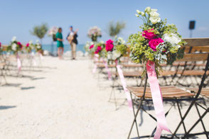 with flowers decorated chairs on beach