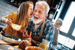 Großvater und Enkelin kochen gemeinsam und haben Spaß