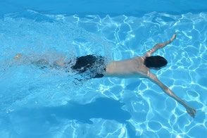 Mann schwimmt im Wasser gegen Widerstand einer Gegenstromanlage