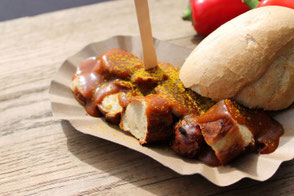 Currywurst in braunem Pappschälchen mit Brötchen