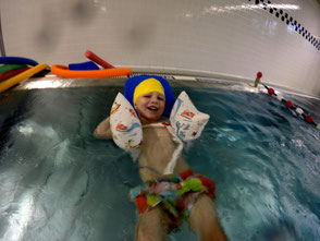 Junge schwimmt im Schwimmkurs auf dem Rücken