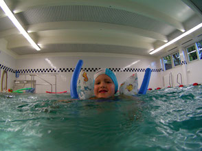 Junge im Schwimmkurs mit Schwimmnudel