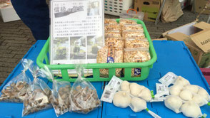 こめる農園∞こめる食堂の大島孝仁さんと、誠子さん。地域の仲間の商品も並ぶ。長野ではポン菓子を「とっかん」という。