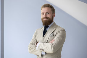 Businessportrait von einem Mann vor einem hellblauen Hintergrund von Angelika Zwick