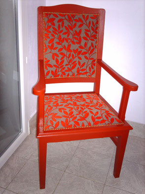 Fauteuil Rustique repeint en rouge et recouvert d'un tissu à motifs de feuilles rouges et taupe finition clous dorés