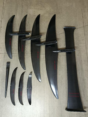 tous les éléments du foil aeromod V3 démontés : mat, 4 ailes, 3 stabs, fuselage arrière, carbone apparent, déco sans les bandes de peintre, sérigraphies des lettres rouge cerise