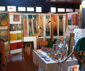 Messestand bei den Naturheiltagen in Bergisch Gladbach mit vielen Bildern im Hintergrund und auf einem Tisch