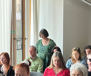 Ina Paulus legt während einer Gruppenheilsession den Teilnehmern die Hände auf