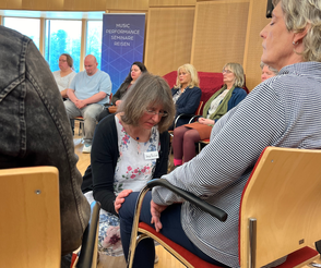 Geistheilerin Ina Paulus legt während einer Healingsession ihre Hände auf die Knie einer Teilnehmerin