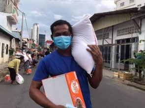 Resident carrying rice of 25 kg in smile