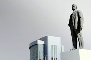 A photograph of a staute of Lenin standing on a block