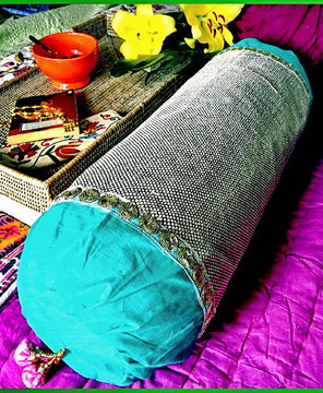 Shimmering bronze, silk-brocade bolster cover with silver/white dots & sky-blue, finely spun, Indian-cotton, trimmed with floral, sequence-net ribbon on either end & gold-bead, pink, pom-pom trinket on one end