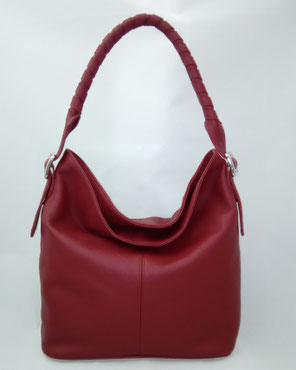 sac seau en cuir rouge porté épaule avec une bandoulière tressée pièce unique fabriquée en France