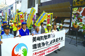 美崎町歓楽街環境浄化総決起大会が行われ、歓楽街を練り歩きPRした=9月29日、市役所前