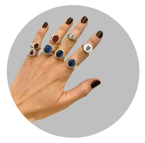 Hand mit Siegelringen aus Gold, Platin und Silber