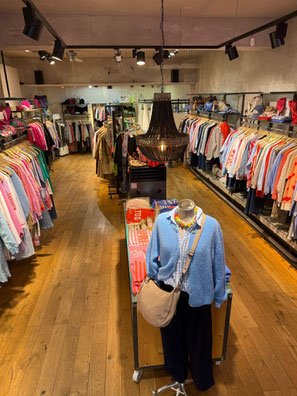 Blick von schräg oben in das Modegeschäft Ollies Fashion von Maria Olberding in Münster mit Kleiderständern und bunter Mode.