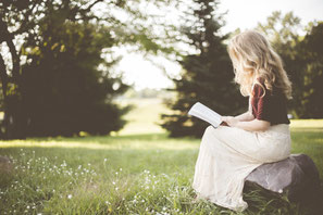 donna che legge libri sui buoni propositi dell'anno, su crescita personale, consapevolezza e serenità in ogni ambito