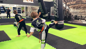 mehrere Kinder bei Trittübungen im Sportkarate Kurs