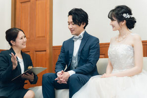 新郎新婦と打ち合わせする結婚式場スタッフ