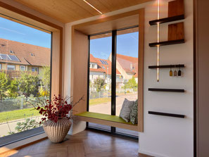 Nachträglich eingebautes Sitzfenster aus Eiche in Geisingen mit integriertem Stauraum und Blick nach draußen.