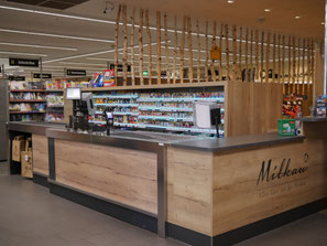 Verkaufstheke und Ladenbau für EDEKA Milkau in Aldingen mit individuell gefertigter Kassenzone und Birkenstämmen als Raumgestaltung