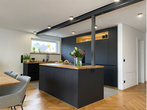 Küche nach Maß in Engen im Hegau – moderne Schreinerküche mit Kochinsel, schwarzen Fronten und Eiche Massivholz von Holzdesign Rapp.