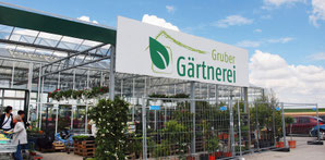 Die Gärtnerei Gruber im Steinweg 10 in Erdmannhausen. Hier als Außenaufnahme mit Parkplatz. Die Gärtnerei befindet sich auf dem offenen Feld, ist mit Fahnen gekennzeichnet.