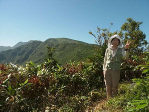 薬師山山頂で七倉、四塚山方面の山をバックにY森