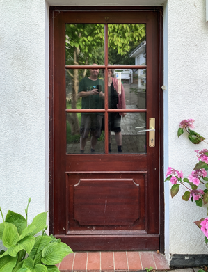 Haustür mit Spiegelung von zwei Personen