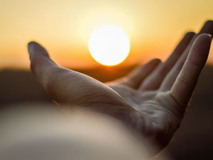 Eine Hand streckt sich der Sonne entgegen