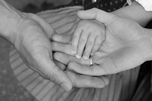 immagine di mani di neo genitori e come la mindfulness aiuta a essere meno critici con maggiore presenza mentale e consapevolezza