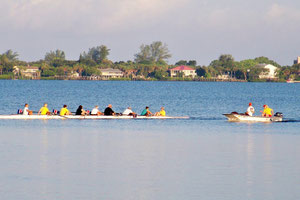 An eight with four newbies and the powered coach's boat following