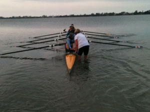 stern view of an eight with oars flat on the water