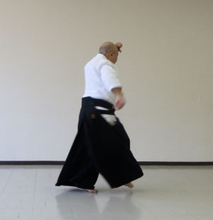 ④右足を後方から前方を経て膝を折って軸足の外側に着地　右手は腰の後ろに置く　額の結びを緩めると回転は不能