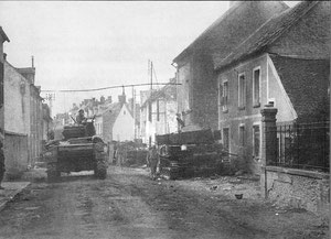 A sherman patrols the streets of Chambois. In this case, the (current) Rue des Polonais, D16. At right, the house where polish and american forces shook hands when they met.