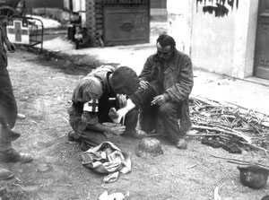 A german soldier gets care from a canadian medic, also in front of L'Hospice. Pay atention to the (Horch) picture above, as both medic and german are visible in the left corner!