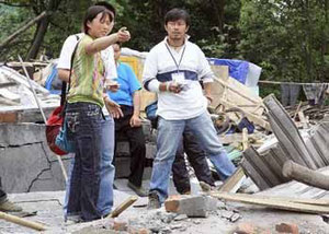 中国・四川大地震の際、被災状況を調べるCODEスタッフ吉椿さん(右)=2008年5月、四川省綿竹市で(読売新聞HP読売国際協力賞より転載)