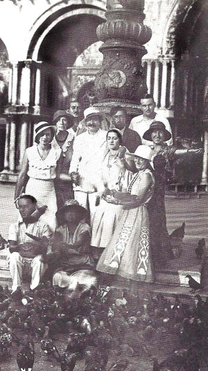 Delia standing left next to Baba