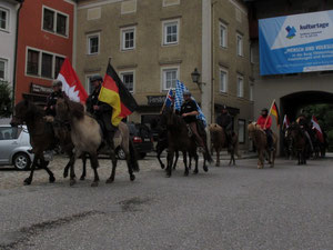 in Formation und mit Fahnen