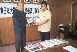 東日本大震災関連の書籍を中山市長に手渡す桃原さん=22日午前、市役所