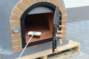 Detailansicht Pizzaofen mit Gusseisentür und Klinkersteinen