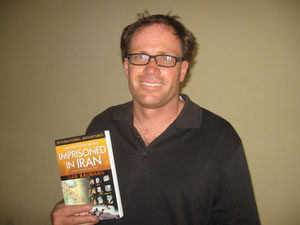 Dan with his book about his experience in an Iranian prison