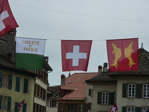 le drapeau vaudois, celui d'Orbe et le drapeau suisse