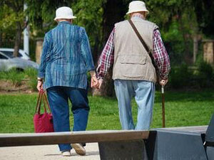 photo d'un couple de personnes âgées marchant main dans la main