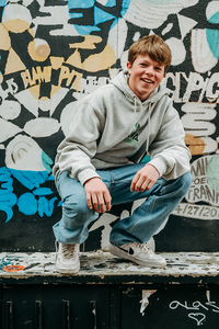 vrolijk portret van jongen bij graffiti- lentefeest-groeifeest-vormsel-portretfotografie-by Fotografils-fotograaf in Essen