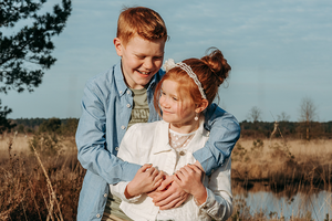 broer en zus in omhelzing in de heide in het avondzonnetje-communie-lentefeest-groeifeest-spontane kinderfotografie-by Ilse Wagemakers-Fotografils-fotograaf-Kalmthout