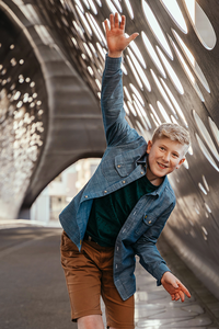 jongen balanceert lachend in de Parkbrug-vormsel-communie-lentefeest-portretfotografie-by Ilse Wagemakers-Fotografils-fotograaf-Antwerpen