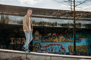 jongen wandelt voorbij grafittimuur-vormsel-communie-lentefeest-portretfotografie-by Ilse Wagemakers-Fotografils-fotograaf-Antwerpen
