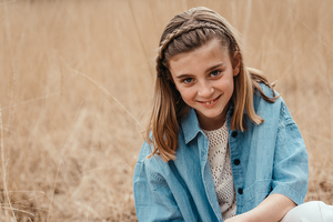 portret van lachend meisje in lang gras-communie-lentefeest-groeifeest-spontane kinderfotografie-by Ilse Wagemakers-Fotografils-fotograaf-Kalmthout
